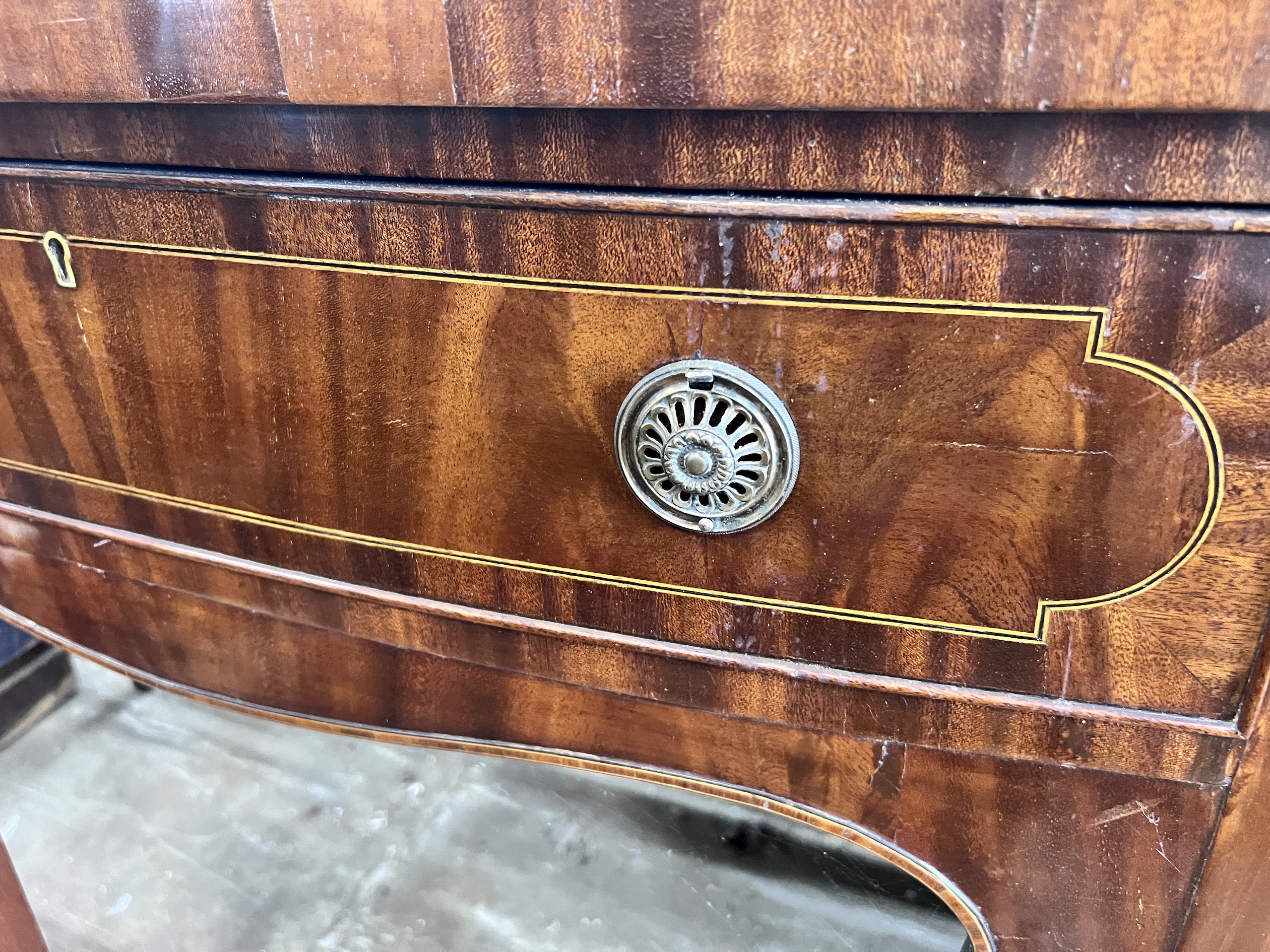 A George III style mahogany serpentine sideboard on square tapered legs, width 184cm, depth 63cm, height 93cm
